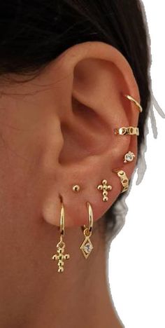 a close up of a person's ear with different types of earrings on it