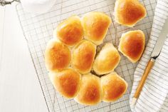 bread rolls on a cooling rack with a knife and napkin next to it, ready to be baked