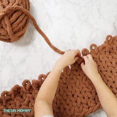 someone is crocheting the ends of a brown bag