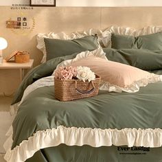 a basket with flowers sitting on top of a bed next to pillows and pillow cases