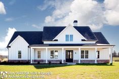 a large white house sitting on top of a lush green field