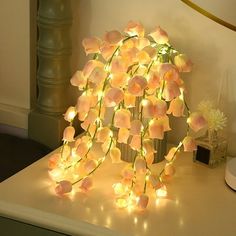 an arrangement of flowers is lit up on a table