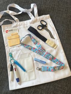 a white bag with scissors and other items on it