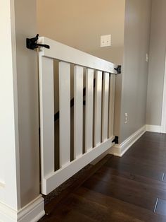 an empty room with hard wood flooring and white railings on the side wall