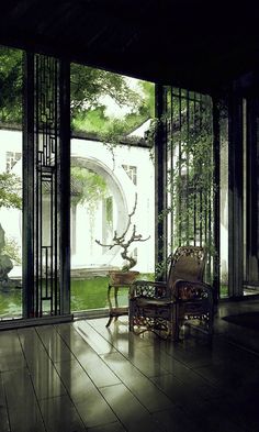 an empty room with wooden floors and glass doors leading to the outside area that is covered in greenery