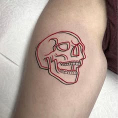 a red and black skull tattoo on the right thigh, which has a line drawing of a human face