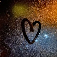 a heart drawn on the window with rain drops