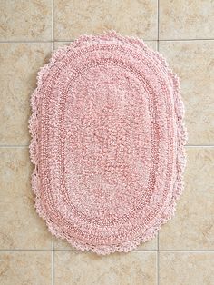 a pink rug sitting on top of a tile floor