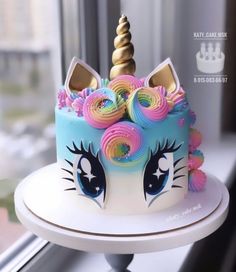 there is a cake that looks like a unicorn's face on top of it