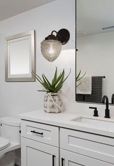 a bathroom with a sink, toilet and mirror in it's centerpieces