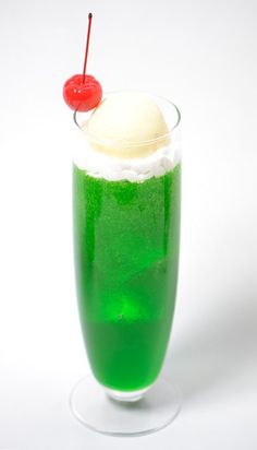 a green drink with ice cream and a cherry on top