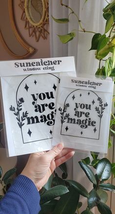 someone holding up two cards with the words you are magic