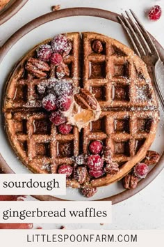 a white plate topped with waffles covered in powdered sugar