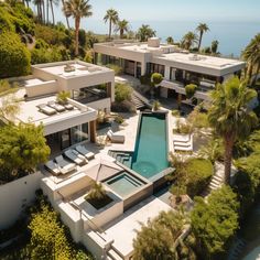 an aerial view of a house with a pool and palm trees in the foreground