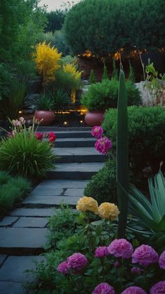 a garden with lots of flowers and plants in the center, along side a walkway