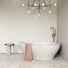 a white bath tub sitting under a chandelier