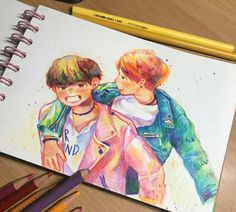 a drawing of two boys hugging each other with colored pencils next to them on a table