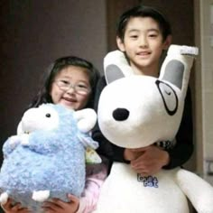 two children holding stuffed animals in their arms