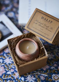 a small candle in a box on a table