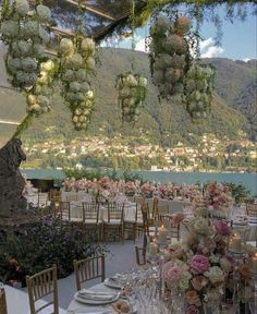 an outdoor dining area with tables and chairs set up for a formal function overlooking the water