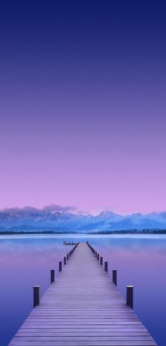 a dock in the water with mountains in the background