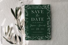 a green save the date card next to an olive branch