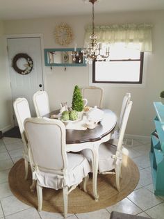 a dining room table with white chairs around it