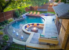 a backyard with a fire pit and seating area next to the pool is lit up