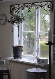 a potted plant sitting on top of a window sill next to a clock