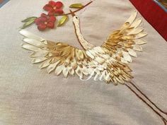 a close up of a bird on a table cloth with flowers in the back ground