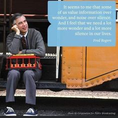 a man sitting on the side of a train next to a sign that says it seems to me that some of us value information over wonder, and noise