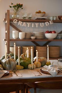 the table is set with pumpkins and gourds