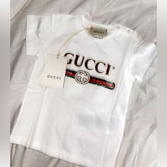 Authentic Purchased From The Gucci Store. Let Me Know If More Pictures Are Wanted ! Tee No Longer Has Tag Attatched- I Still Have Tag Though And It’s Very Easy To Put Back On If That’s Wanted. Just Have To Dig To Find It Gucci White T-shirt With Letter Print, White Gucci T-shirt With Logo Print, Gucci Cotton Tops With Letter Print, Gucci Cotton Tops With Embroidered Logo, Summer Cotton Gucci T-shirt, Summer Gucci Cotton T-shirt, Cute White Top With Embroidered Logo, Cute White Tops With Embroidered Logo, Gucci Sweatshirt