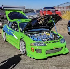 a green sports car with its hood open and the engine in the trunk is parked