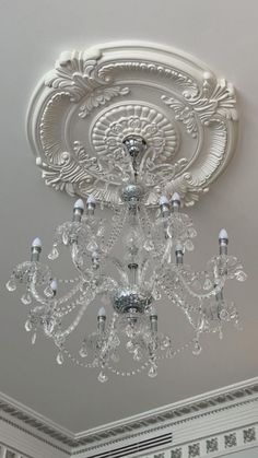 a chandelier hanging from the ceiling in a room with white walls and ceilings