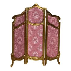 a pink and gold room divider sitting on top of a white floor