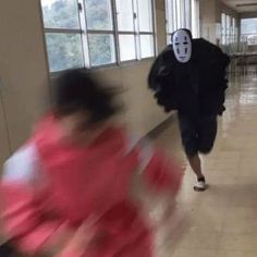 two people in masks are running down the hall