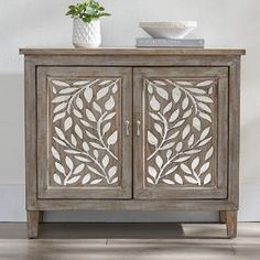 a cabinet with an intricate design on the front and side doors, sitting against a white wall