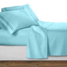 a bed with blue sheets and pillows on it