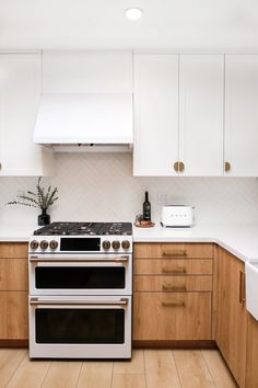 a white stove top oven sitting inside of a kitchen next to wooden cabinets and counter tops