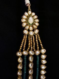 Aza Multi-String Emerald & Polki Pendant Statement Necklace Absolutely stunning Glamorous Green Emerald Gemstones and Kundan /Polki Necklace . This necklace comprises two strands of graduated lush ivory glass simulated pearls and emeralds secured by a spectacular Art Deco style push in box clasp which is encrusted with sparkly round pearl drops at the bottom of the pendant. Pair it with a choker to get the bridal look! Approximate mala length is 20". A complete synergy between traditional ae Traditional Green Hand-strung Jewelry, Hand-strung Pearl Necklaces For Weddings, Hand-strung Pearl Wedding Necklaces, Green Pearl Pendant Jewelry For Formal Occasions, Formal Green Pearl Pendant Jewelry, Traditional Hand-strung Dangle Jewelry, Formal Green Hand-strung Jewelry, Green Pearl Drop Jewelry With Round Beads, Green Pearl Drop Jewelry For Celebration