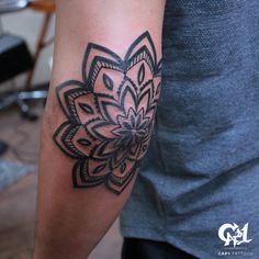 a man with a tattoo on his arm has a black and white flower design on it