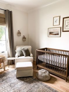 a baby's room with a crib, chair and ottoman