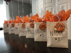 bags with name tags are lined up on a table in front of a door that says nadda