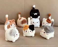 crocheted stuffed animals are sitting on a couch with one cat in the middle