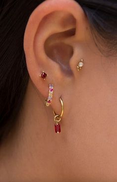 a close up of a person's ear with two different colored stones on it