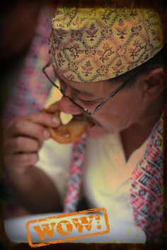 a man eating a doughnut with the word wow written on it in orange and white