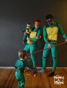 three people in green and yellow costumes standing on wooden floor