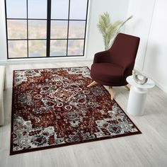 a living room with a chair, rug and large window overlooking the cityscape