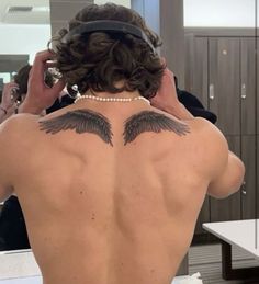 the back of a woman's head with wings on it